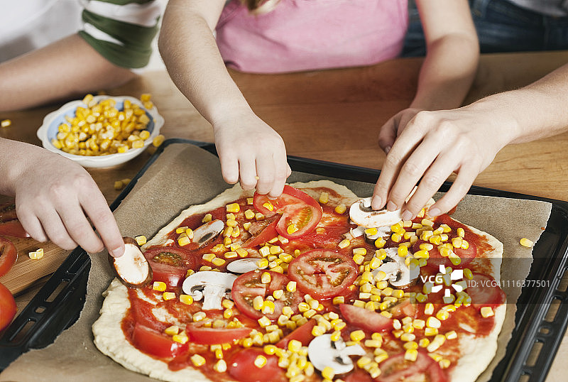 德国科隆：母亲和孩子们装饰披萨图片素材