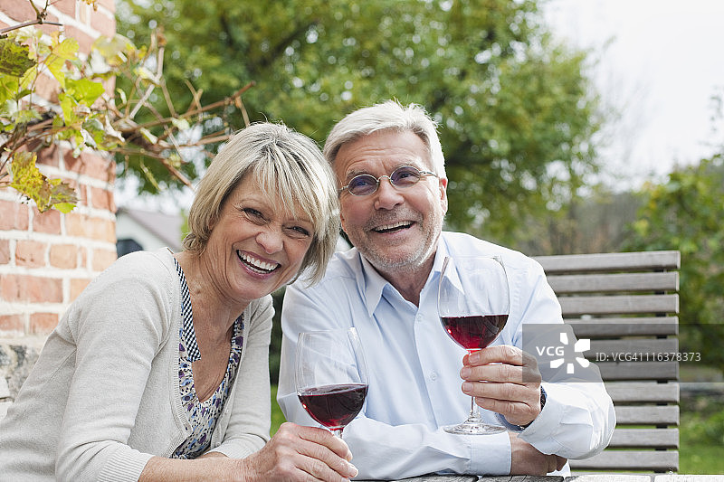 德国克拉策堡，老年夫妇在乡间小屋附近品酒图片素材