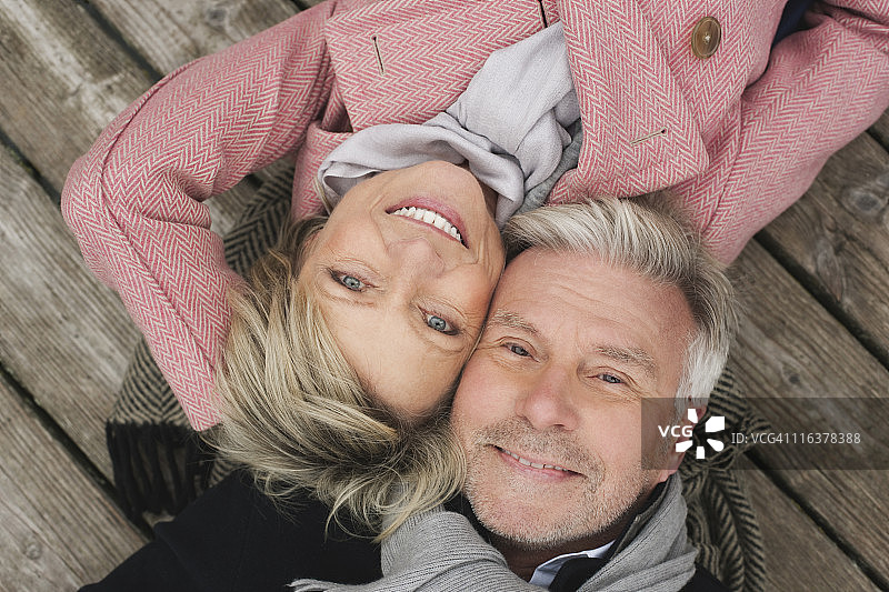 德国克拉策堡，老年夫妇躺在木板路上微笑图片素材