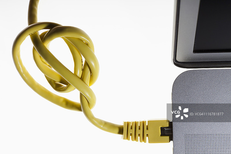 插入笔记本电脑的缠结网络线图片素材