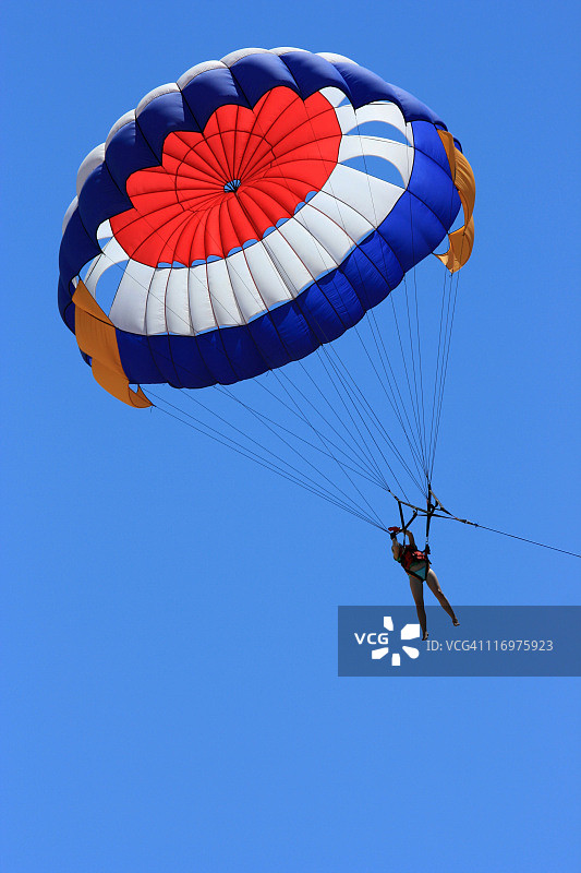 一个人在蔚蓝的天空中玩滑翔伞图片素材
