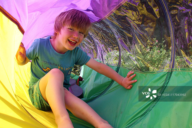 男孩在彩色隧道玩耍图片素材
