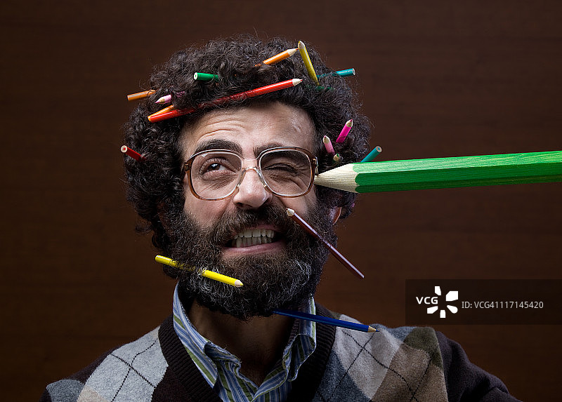 头顶上有很多蜡笔的卷发男士图片素材