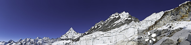 登山者攀登尼泊尔喜马拉雅山脉的冰川高峰全景图片素材