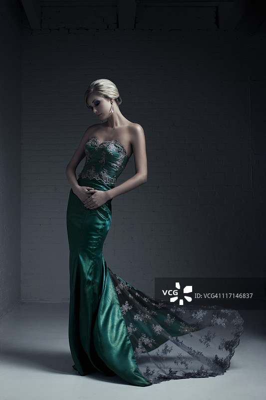 身穿绿色晚礼服的金发女模特肖像图片素材