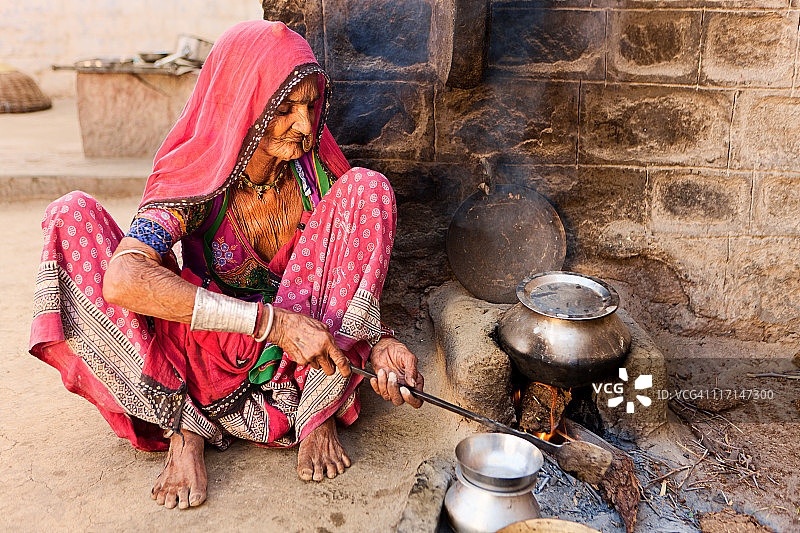 印度老年妇女在拉贾斯坦邦比什诺伊村准备食物图片素材