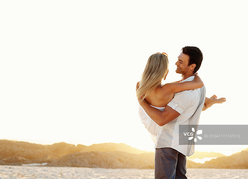 微笑的男人抱着他的女朋友图片素材