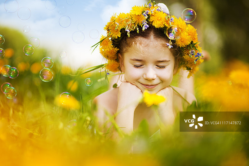小女孩躺在蒲公英田野上图片素材
