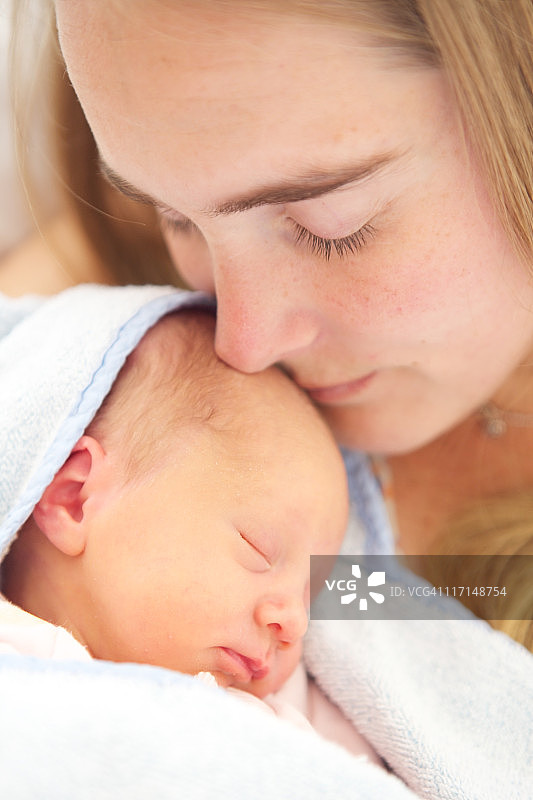 女人抱着她出生2天的女儿图片素材