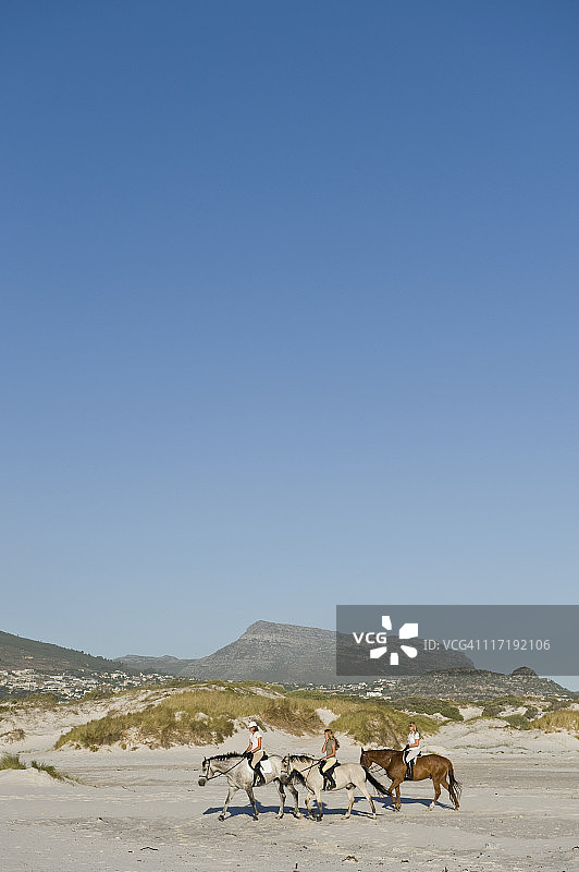 3人在海滩上骑马图片素材