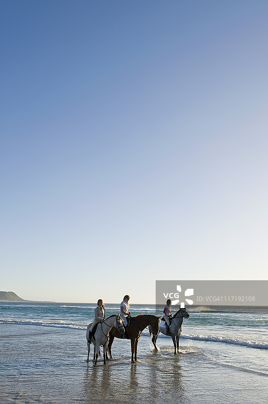 3人在海滩上骑马图片素材