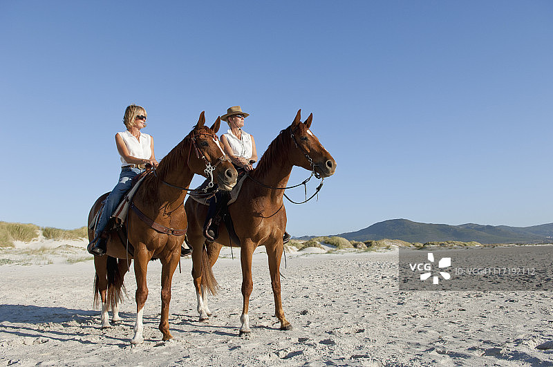 2人在海滩上骑马图片素材