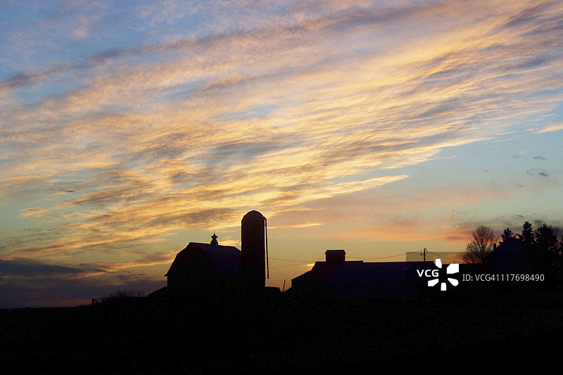 夕阳下的农田与农场建筑轮廓图片素材