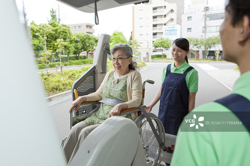 医护人员帮助坐在轮椅上的老年妇女进入面包车,日本本州岛神奈川县图片素材