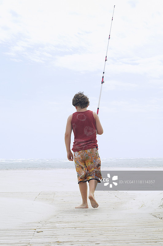 男孩在海滩钓鱼图片素材
