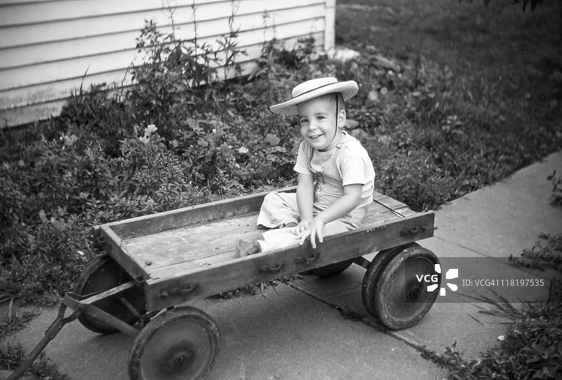 1954年复古老式四轮车上的男孩图片素材