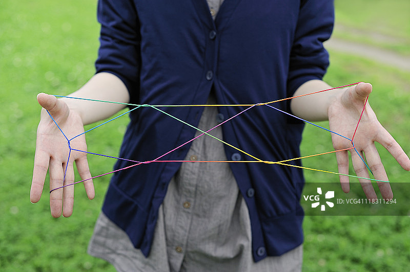 年轻女人玩挑绳游戏图片素材