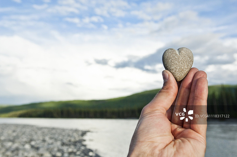 某人手持心形石头图片素材