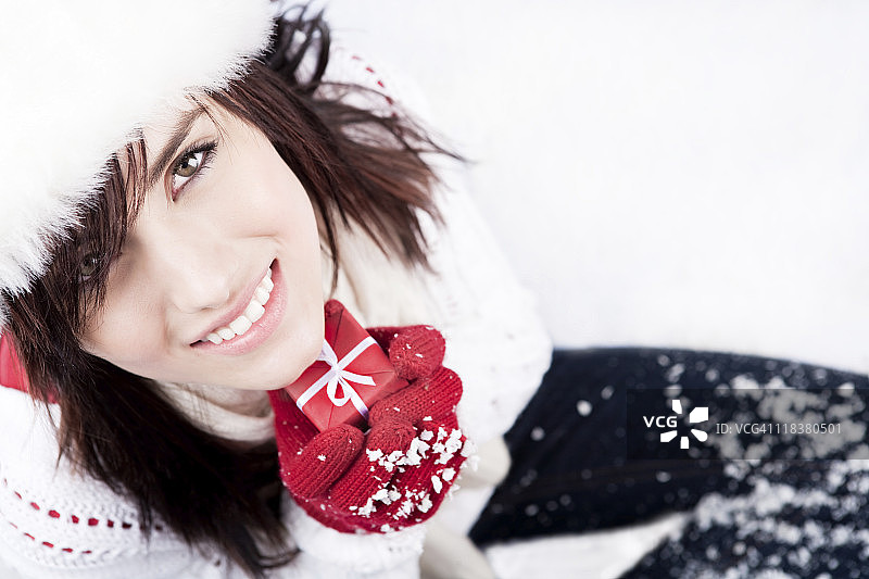 手持红色圣诞礼物的微笑女人图片素材