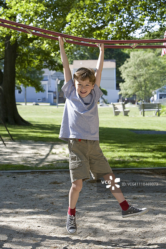 男孩在攀爬架上玩耍图片素材