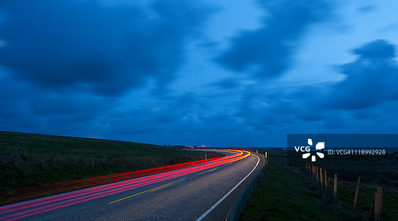 夜间道路弯道上的汽车灯光图片素材
