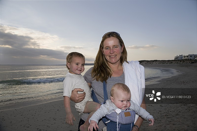 母亲和两个儿子站在南非兰格班天堂海滩上图片素材