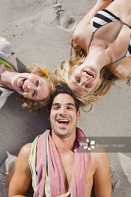 人们排成队形躺在海滩上图片素材