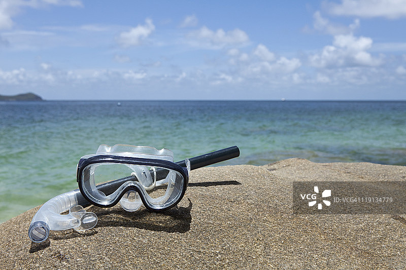 海边岩石上的潜水面罩和呼吸管图片素材