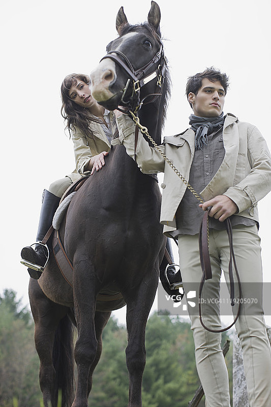 年轻男子引导女子骑马图片素材