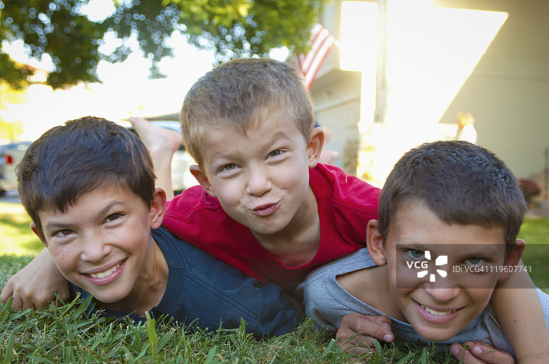 三个兄弟躺在草地上图片素材