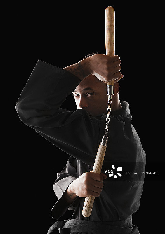 男子使用双截棍的影棚拍摄图片素材