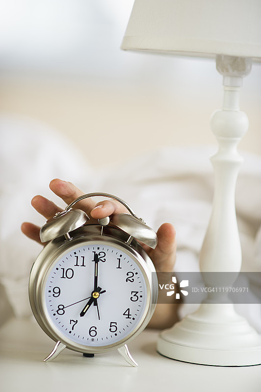 男人伸手关掉床头闹钟特写图片素材