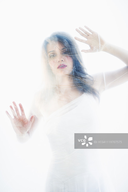 美国新泽西州泽西市：躲在白布后面的年轻漂亮女人图片素材