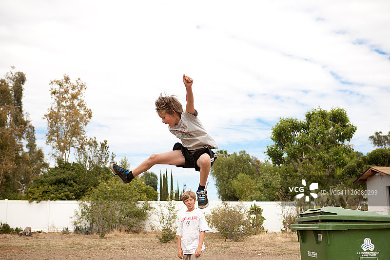 孩子们在后院垃圾桶上跳跃图片素材
