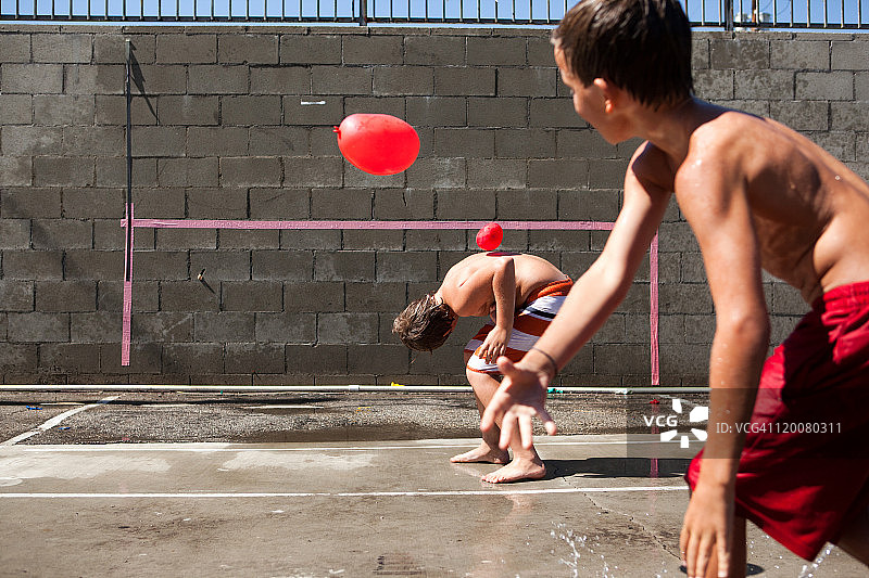 男孩们在水泥砖墙上打水球图片素材