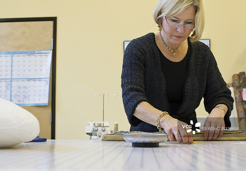 女人用针固定坐垫套图片素材