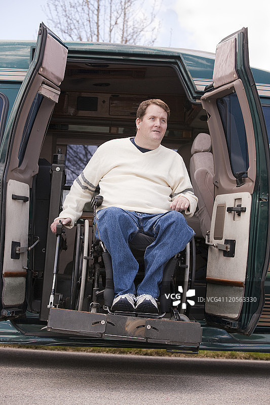 坐在轮椅上的脊髓损伤男子从无障碍厢型车里出来图片素材
