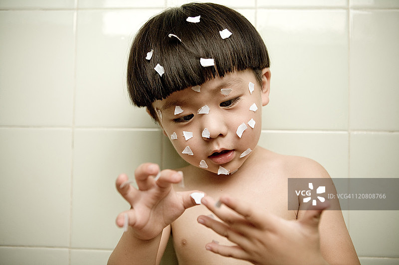 小男孩玩小纸片图片素材