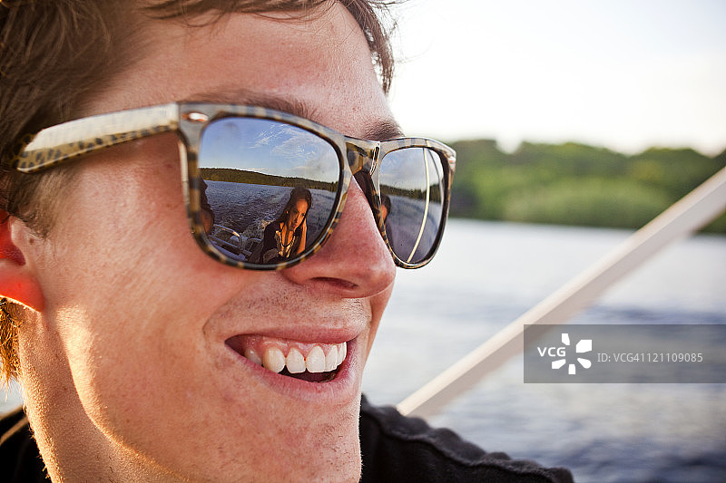 戴墨镜的年轻人在船上图片素材