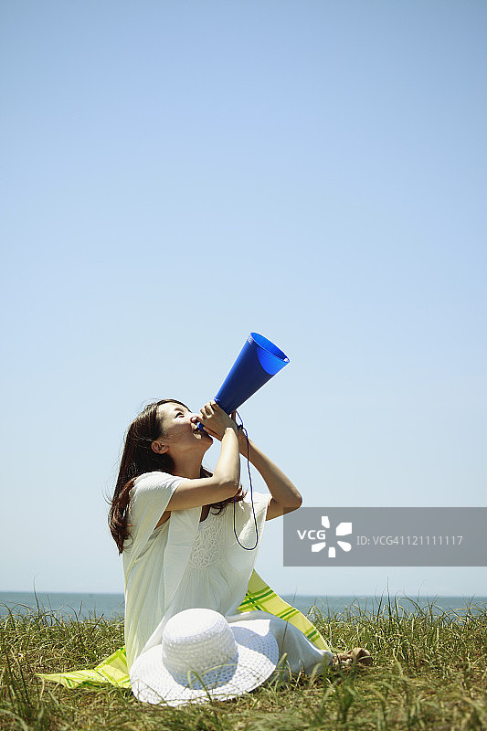 用扩音器欢呼的年轻女人图片素材