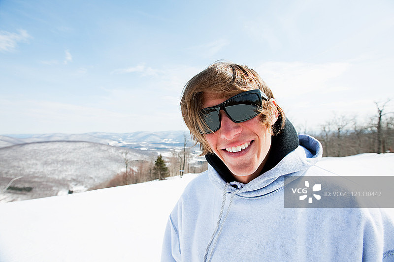 戴着太阳镜和连帽上衣的年轻男人肖像图片素材