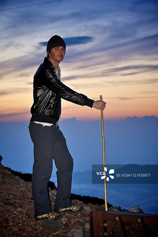 男子在富士山拄着登山杖徒步图片素材