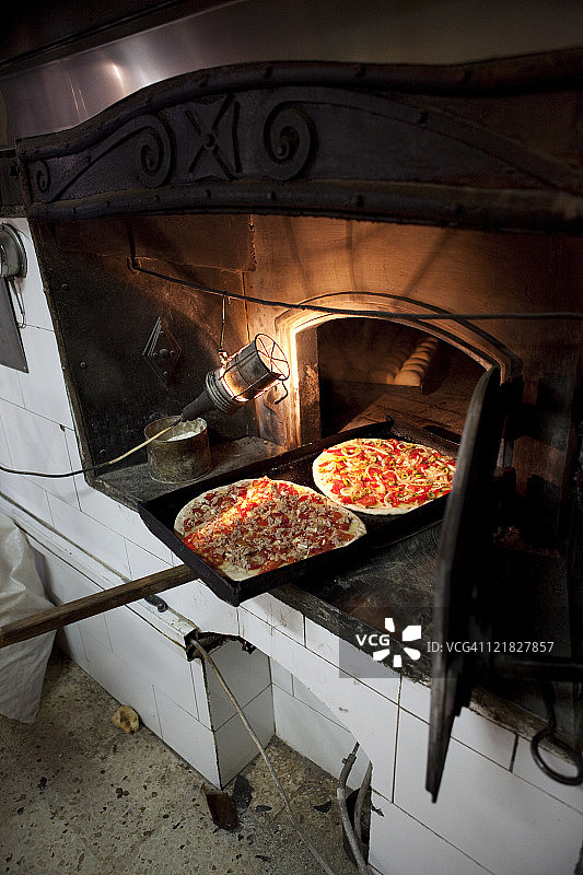 在传统披萨烤箱中烹饪披萨图片素材