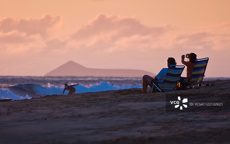 在夏威夷可爱岛拍摄日落时分的冲浪者图片素材