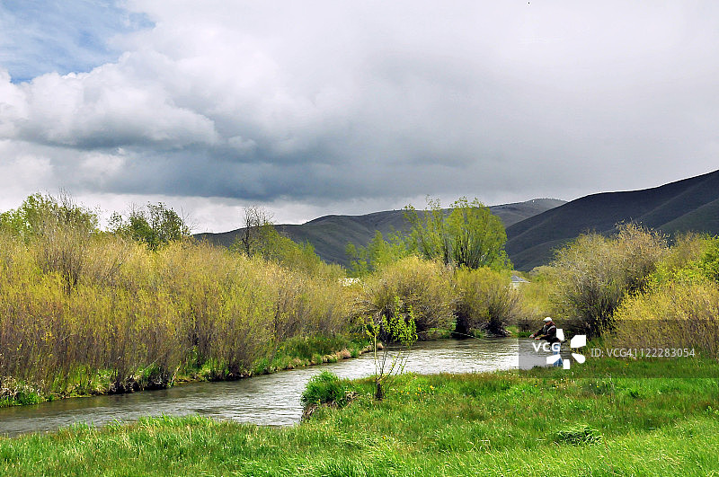 在河里钓鱼的男人图片素材