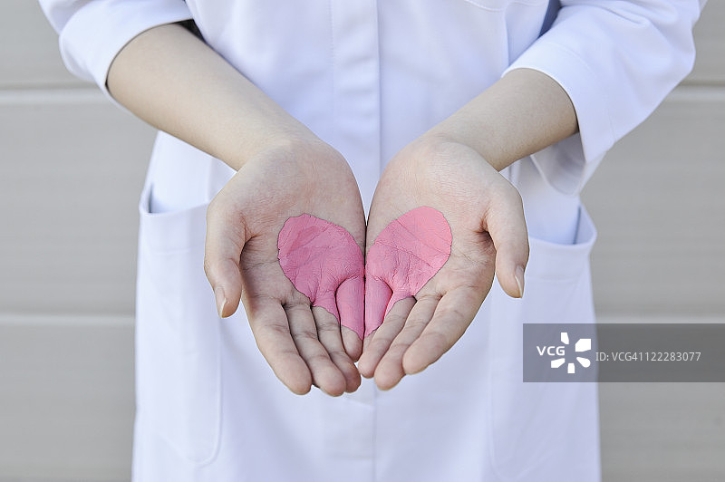 手掌中绘制的心形图案拼合在一起图片素材