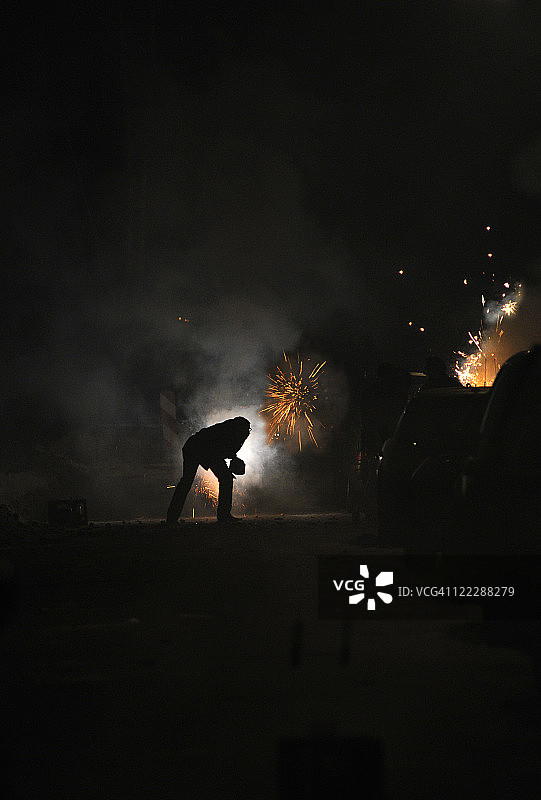 男人在除夕夜燃放烟花图片素材