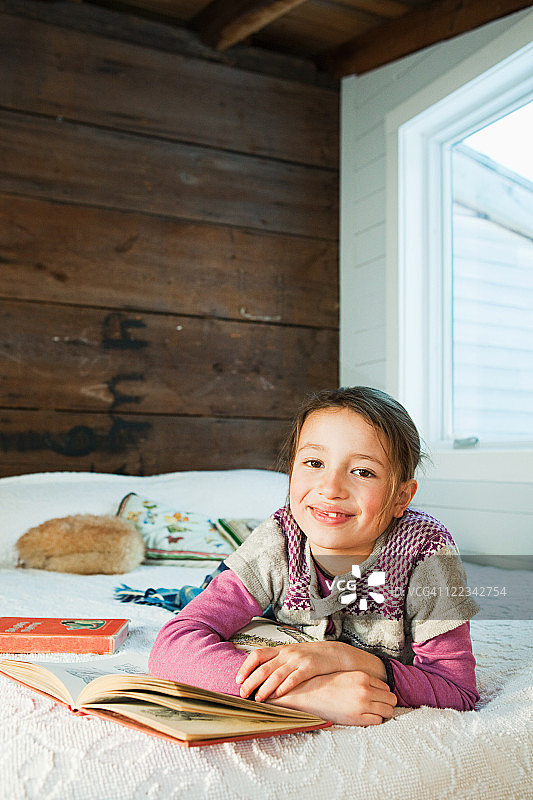 躺在床上看书的年轻女孩图片素材