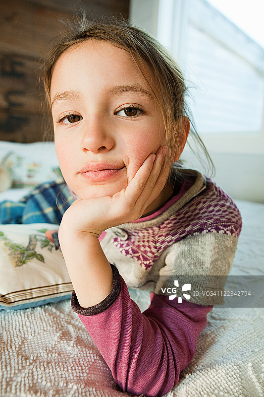 躺在床上看着镜头的年轻女孩图片素材