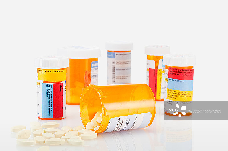 药丸容器和洒落的药丸图片素材